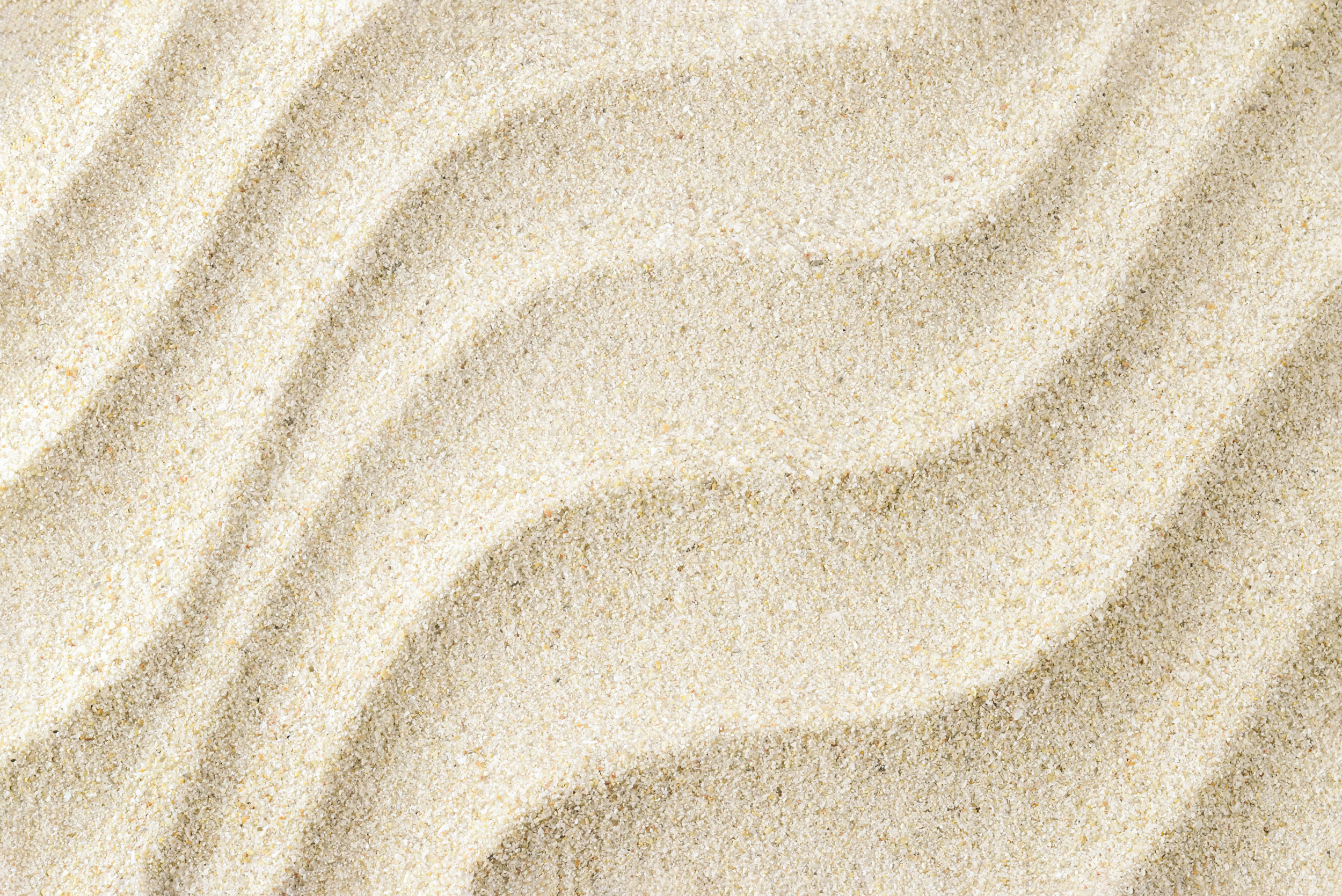 Текстура светло-бежевый мелкий и кварцевый белый песок с волнистыми линиями.