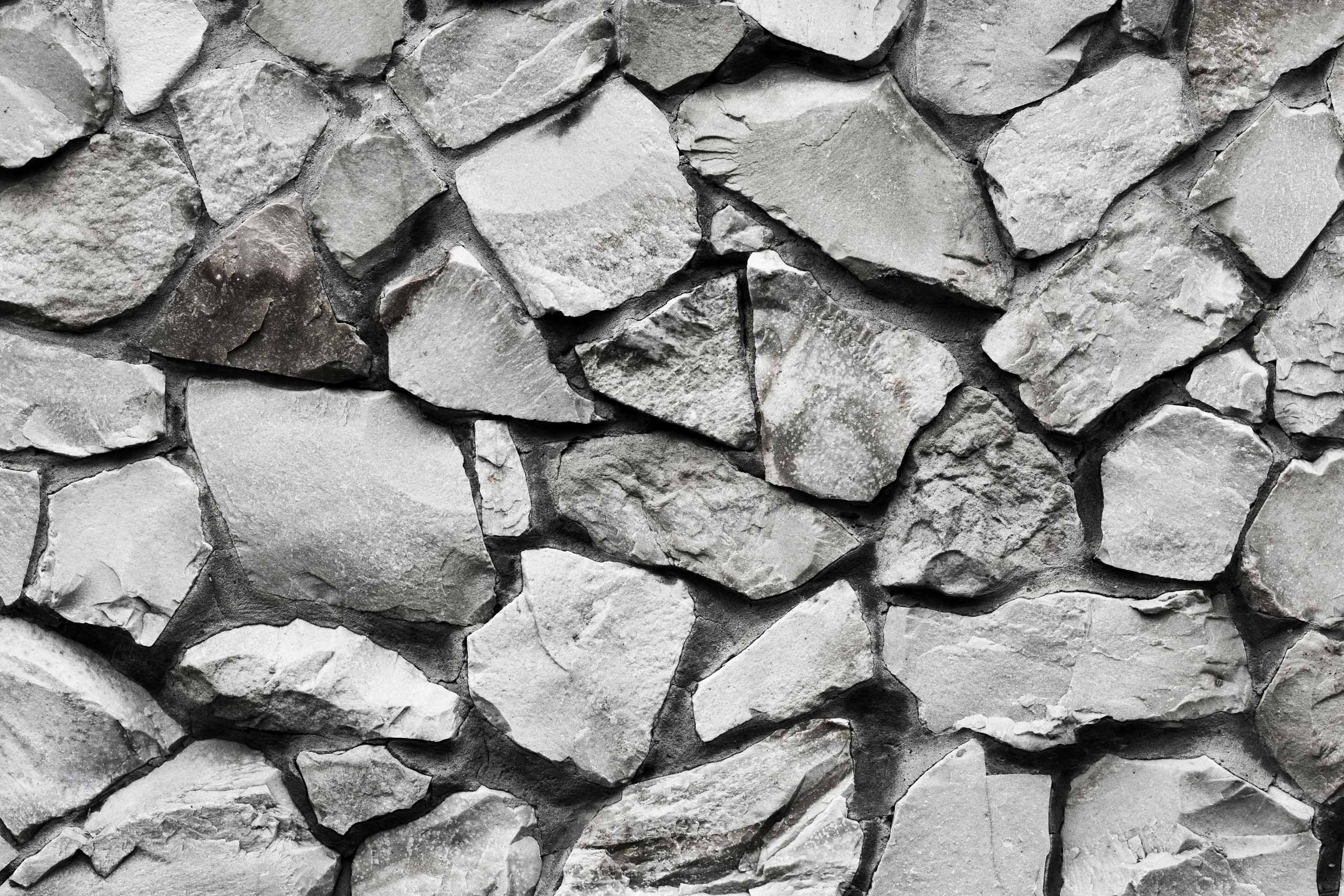 Фотография текстура каменной стены серого цвета из обтёсанных валунов.
