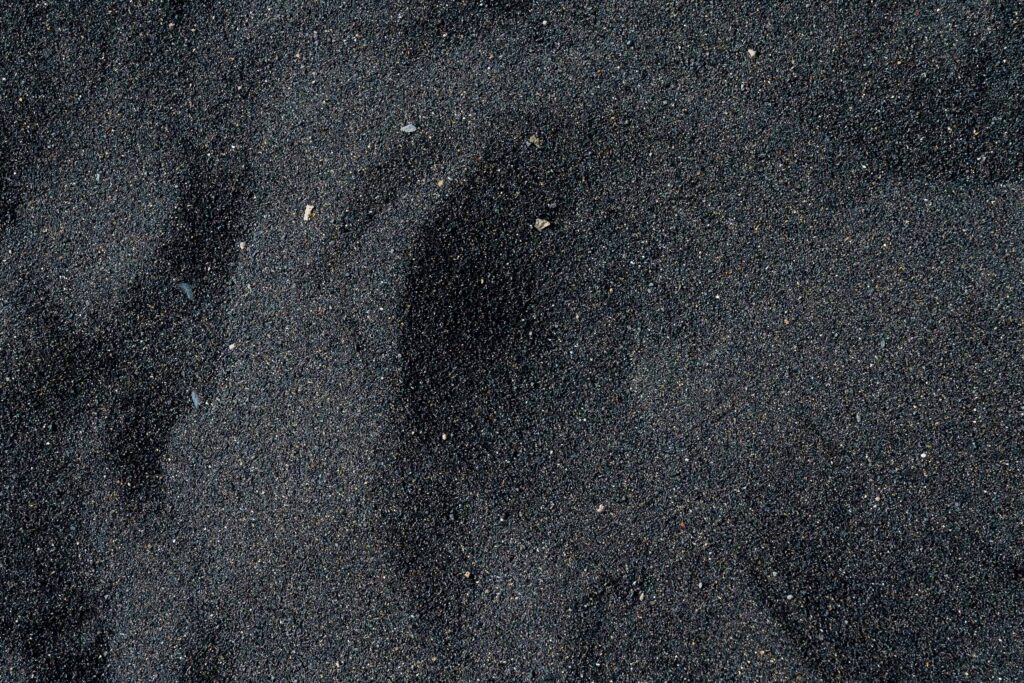 Фотография текстура черного зернистого песка.