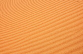 Текстура оранжевого песка с волнами.