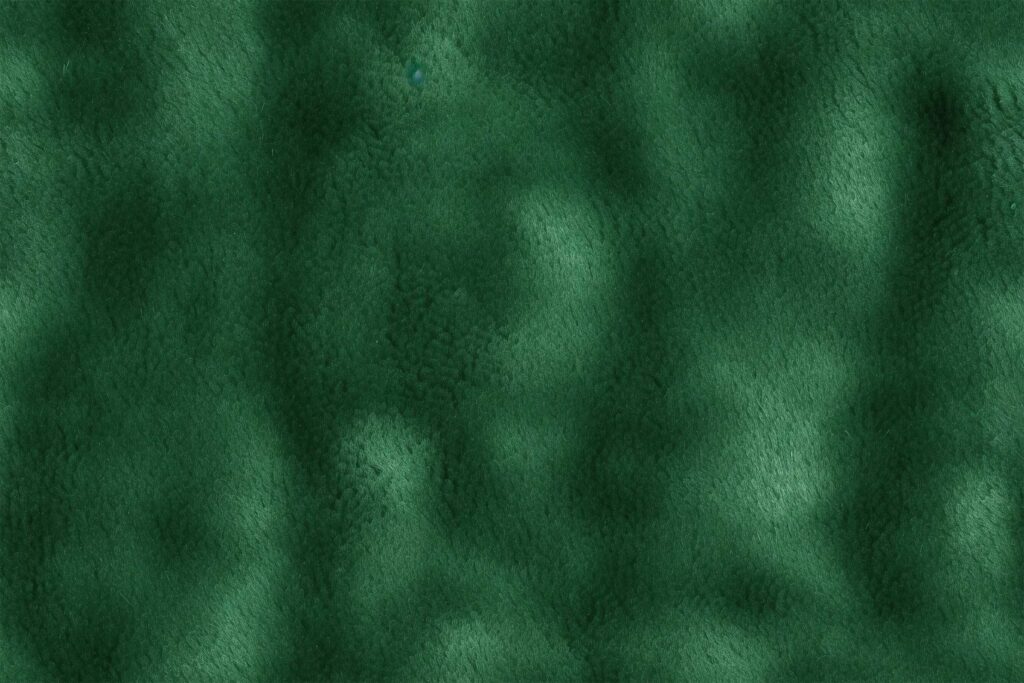 Изумрудный фон ткани - бесшовная текстура зеленый велюр.